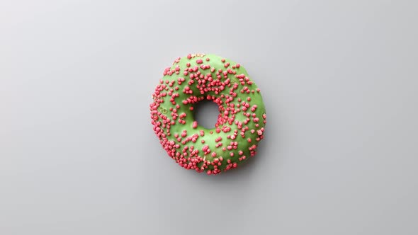 Tasty Appetizing Donut with Green Chocolate Glaze Rotating Isolated on Gray