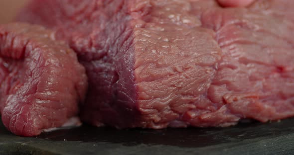 Men's Hands with a Knife Cut Raw Beef To Pieces. 