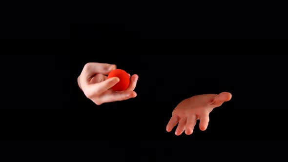 Magician Performing with Two Red Balls on Black Background