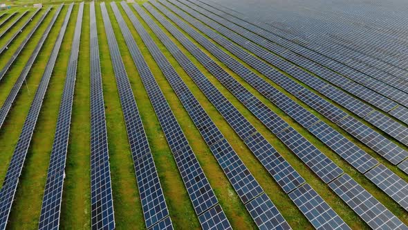 Drone flight over solar panels field, renewable green alternative energy concept.