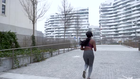 Slow motion shot of sporty young woman jogging in the city