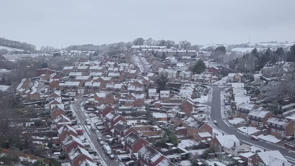 High sideways tracking drone shot of snowy Exeter subburbs CROP