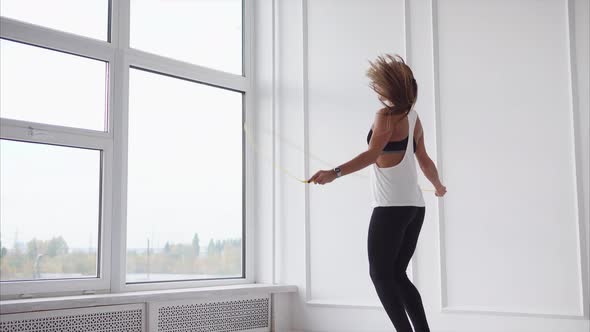 Young and Athletic Woman Warms Up Muscles Lady Jumps Quickly on Rope