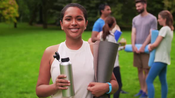 Smiling Woman with Yoga Mat Over Group of People