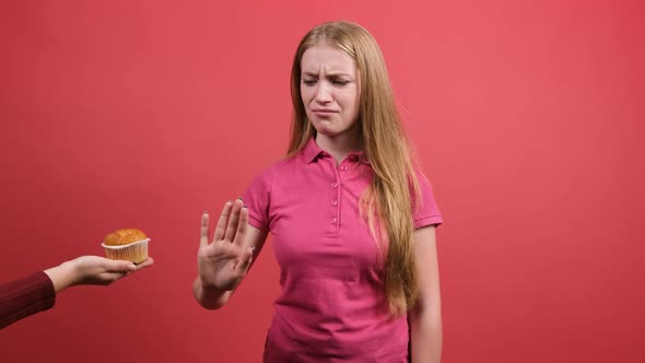 A Girl Who Refuses a Muffin Showing That She Has an Apple.