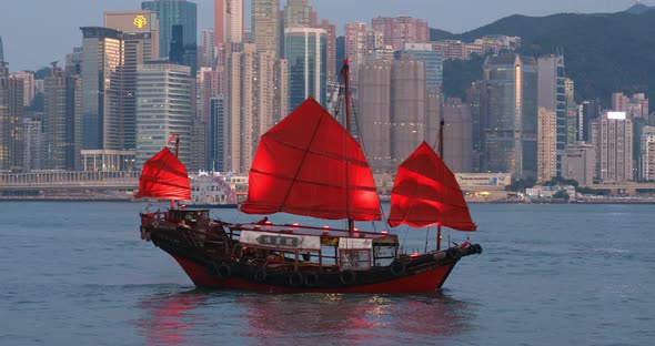 Hong Kong city with red sailing boat on Victoria Harbor 