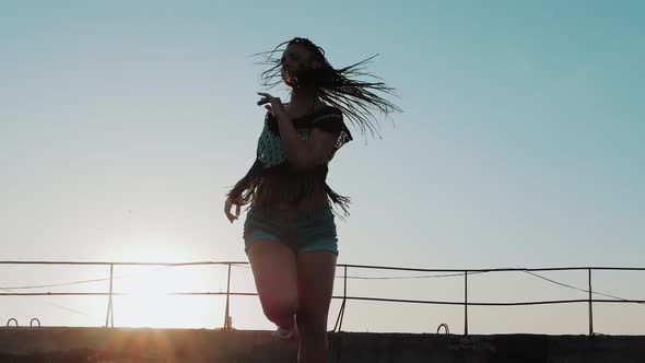 Dancing Female. silhouette happy mixed race woman dancing performance with long dreadlocks in shorts