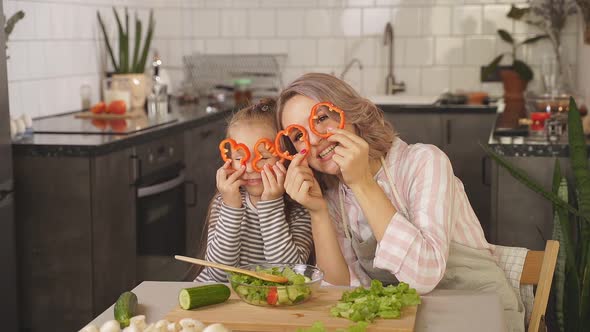 Happy Family a Little Girl and Her Mother Have Fun Together in the Kitchen Closing Their Eyes with