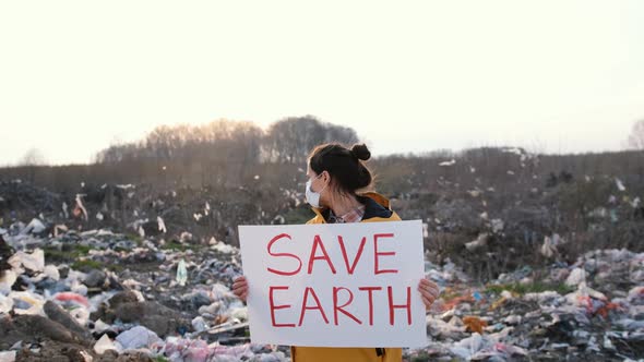 A Young Woman Activist with a Poster in Her Hands Saves the Planet Stands in the Middle of a