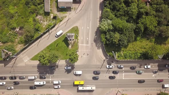 Top down aerial view of busy street intersection with moving cars traffic.