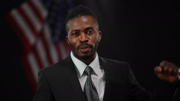 Portrait of Male African American Political Candidate Talking Showing Strength Gesture Looking at