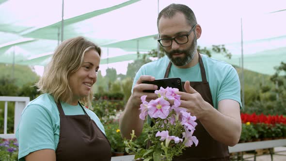 Gardeners Talking at Work Taking Pictures of Flower in Pot