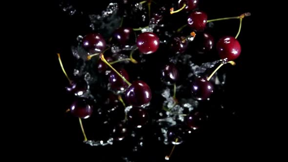 Top View of the Dark Red Cherries Bouncing Up on a Black Background