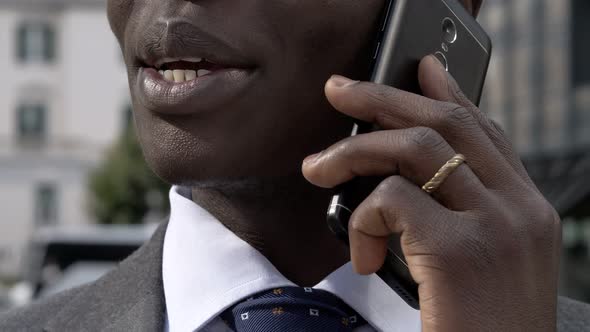 Black african business man talking by phone in the city - close up