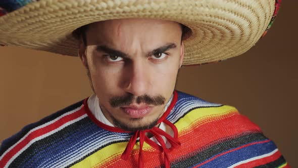 Young Mexican In Multicolored Poncho And Hat