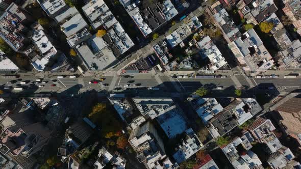 Aerial Birds Eye Overhead Top Down Panning View of Cars Driving on Wide Street Surrounded By Blocks