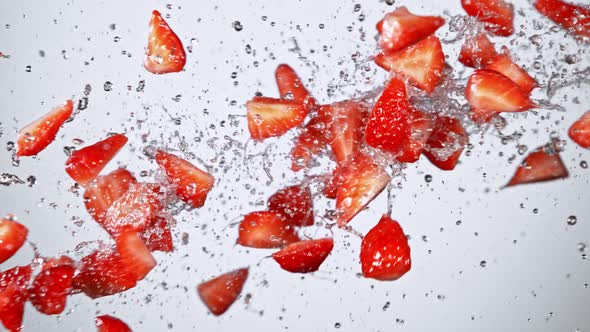 Super Slow Motion Shot of Fresh Strawberries and Water Side Collision on White at 1000Fps.