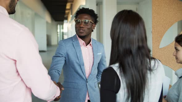 Smiling Man Shaking Hands with Colleagues