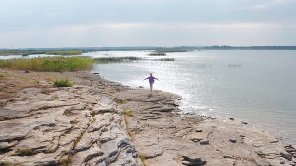 The Girl is Doing Fitness on the Lake Shore