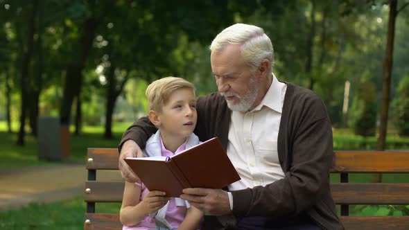 Grandfather and Grandson Discussing Book, Spending Time Together, Education