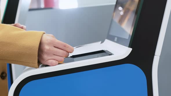 White Woman Hand Applying Paper Ticket to Screen of Automatic Gate at Airport