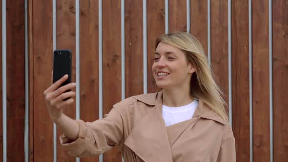 Charming Woman Using Smartphone for Video Chat Outside