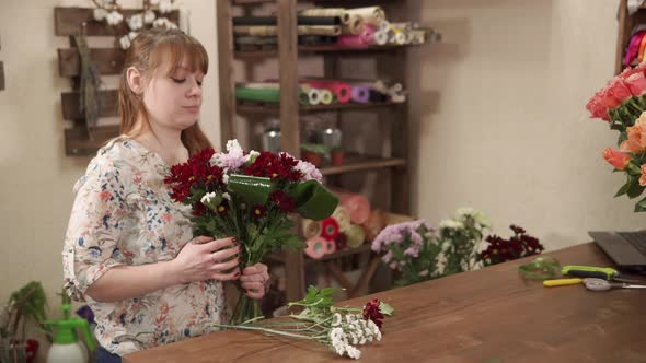 Girl Is Preparing Bouquet of Flowers and Greenery for Trading in a Floral Shop