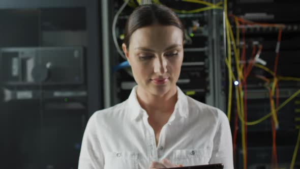 Portrait of smiling caucasian female it technician by computer server