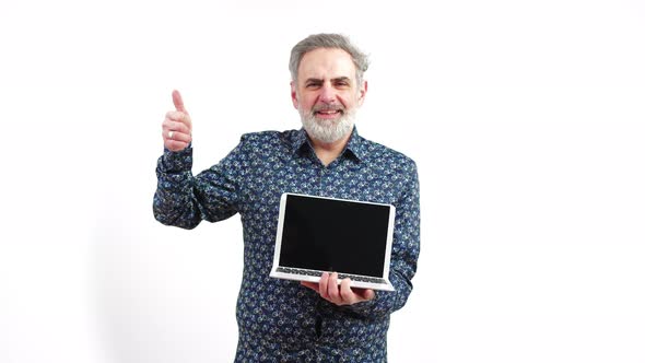 Mature Bearded Man Shows Laptop with Black Screen and Shows the Sign Thumb Up Smiling White