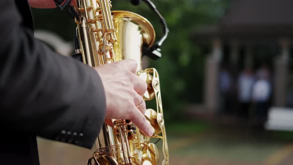 Close Up Futage of Musician Saxophonist Plays Music on His Instrument in a Sunny Summer Day