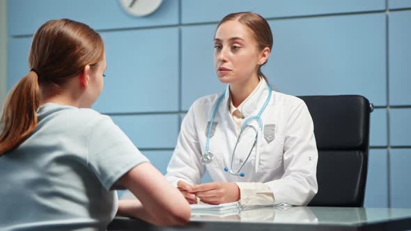 Smiling blonde general practitioner in white coat