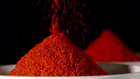 SLOW MOTION: Red Pepper Powder Pouring Into A White Bowl - Close Up