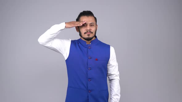 Confident Indian young man saluting towards the camera