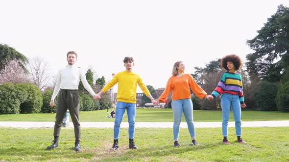 Slow motion group of four people friends jumping outdoor backlight excited