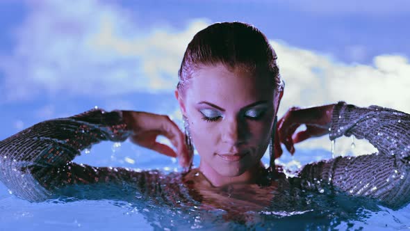 Beautiful Woman Posing in Pool Water Under Neon Color Light