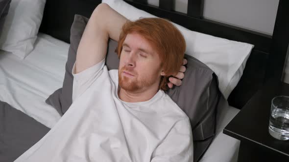 Young Tired Redhead Man Sleeping in Bed