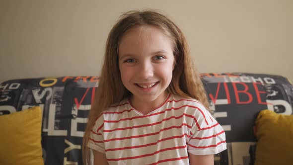 Portrait of Happy Blonde Girl Looking Into Camera and Laughing Indoor