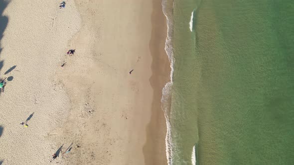 Aerial perspective of half golden sand and half aqua green sea ocean.