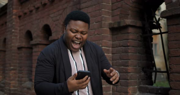 African Guy with Smartphone Looking Very Happy.
