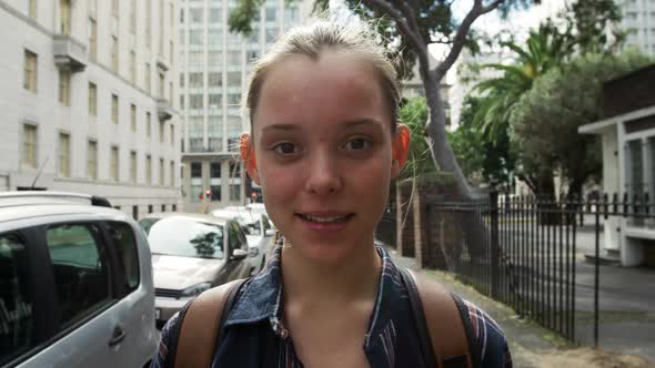 Front view of a Caucasian girl in the street looking at camera