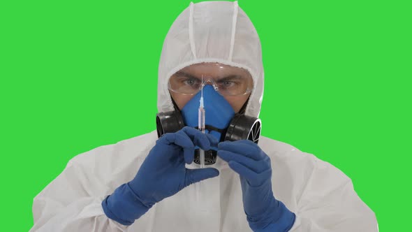 Scientist in Protective Gear Holding Syringe with Injection on a Green Screen, Chroma Key