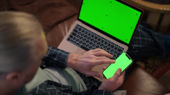 High Angle View Caucasian Man Using Green Screen App on Smartphone Surfing Internet on Chromakey