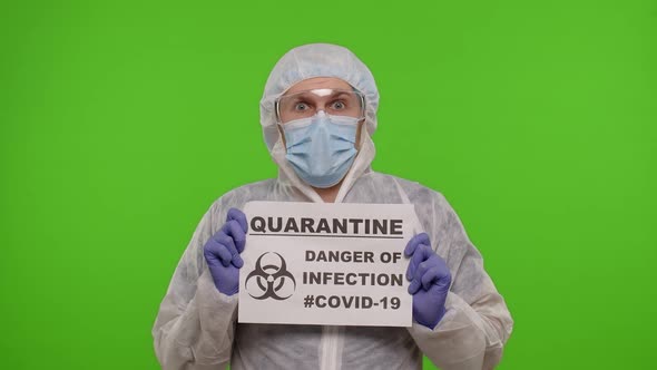 Doctor in PPE Suit Showing Warning Text Slogan on Paper  Quarantine Danger Of Infection Covid19