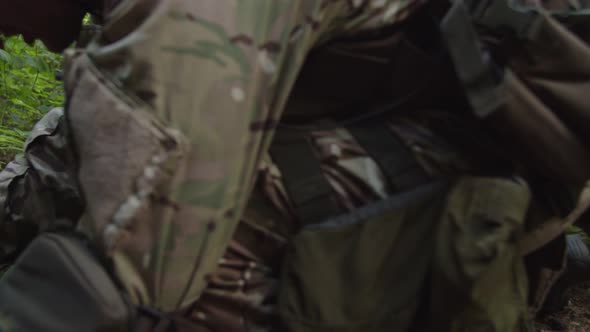 Closeup of Combat Medic Applying Tourniquet to Wounded Leg of Soldier