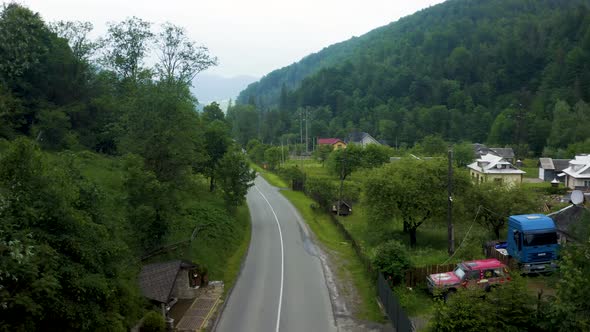 Aerial View of a Road in the Middle of the Green Forest