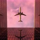 Airplane Flies In The Sky At Sunset Over Skyscrapers - VideoHive Item for Sale