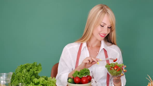 Beautiful Woman Eating Fresh Salad of Organic Vegetables