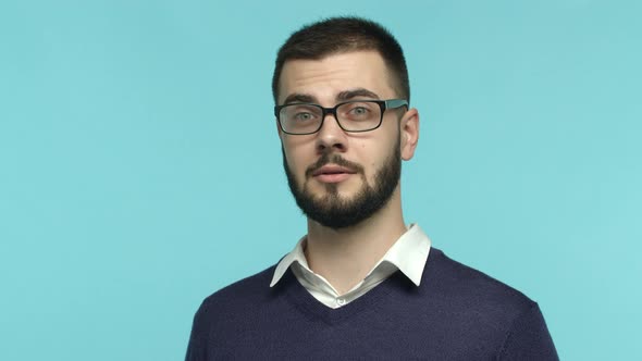 Close Up of Handsome Bearded Man in Glasses Raising Eyebrows Surprised Then Smiling and Looking