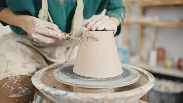 Close Up of Potter Removing Extra Clay From Ceramic Pot Working with Cutter and Pottery Wheel Slow