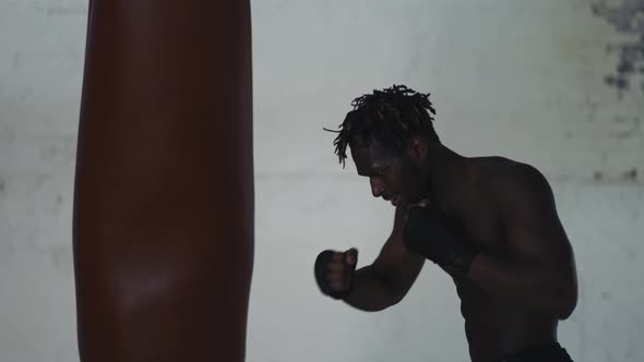 Shirtless Boxer Punching the Heavy Bag Aggressively Shout with Anger